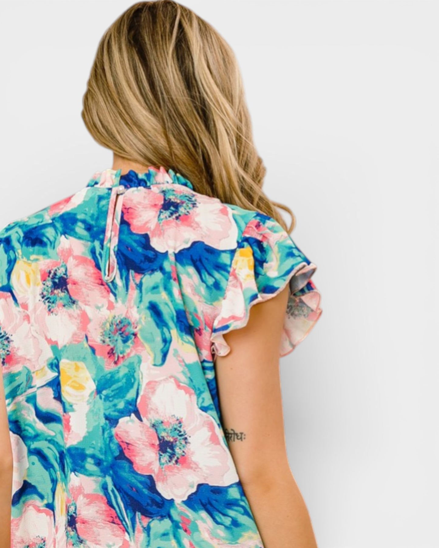 Woman wearing a colorful floral dress against a white background