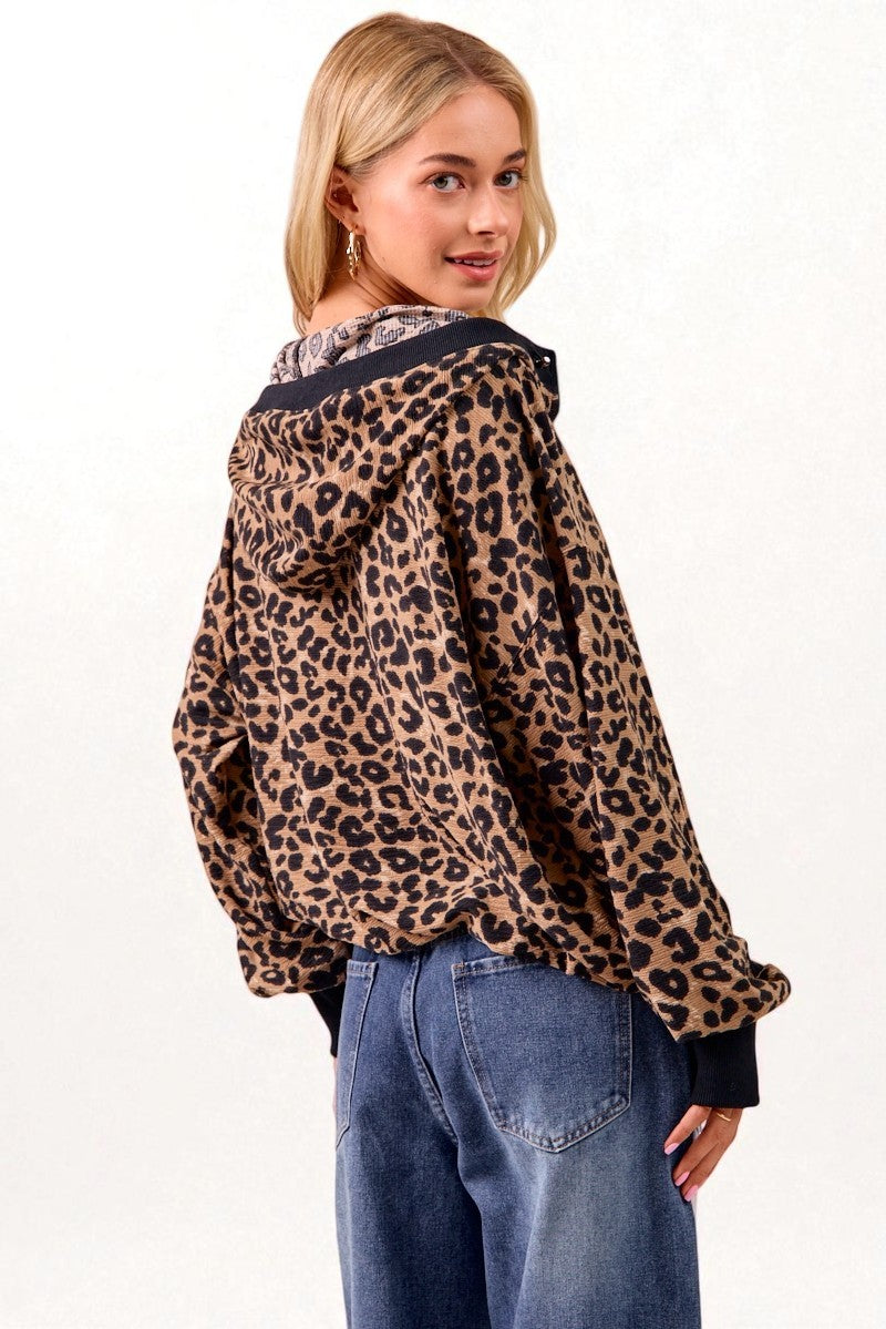 Woman wearing a leopard print jacket and blue jeans on a white background
