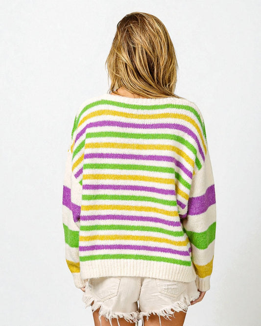 Person wearing a colorful striped sweater on a white background