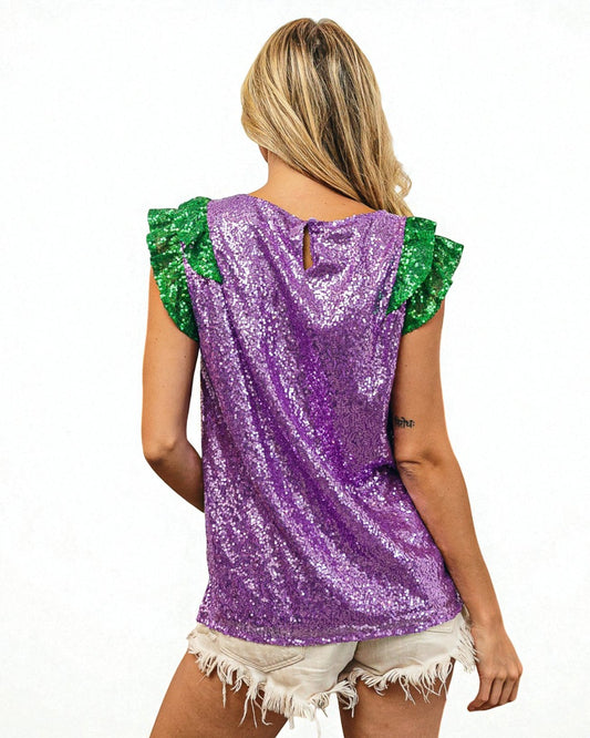 Person wearing a purple sequin top with green sleeves on a white background