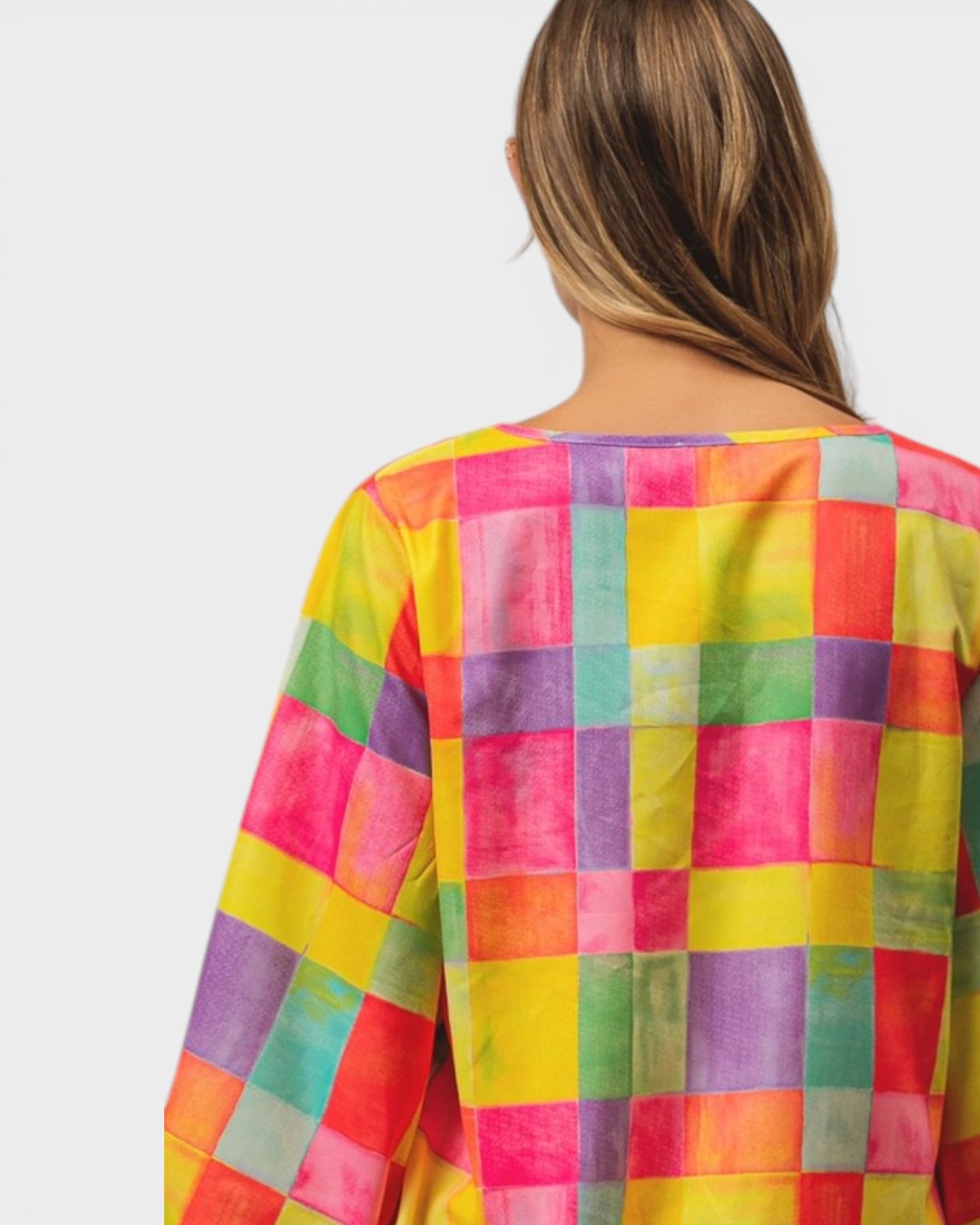 Multicolored checkered shirt worn by a person on a white background