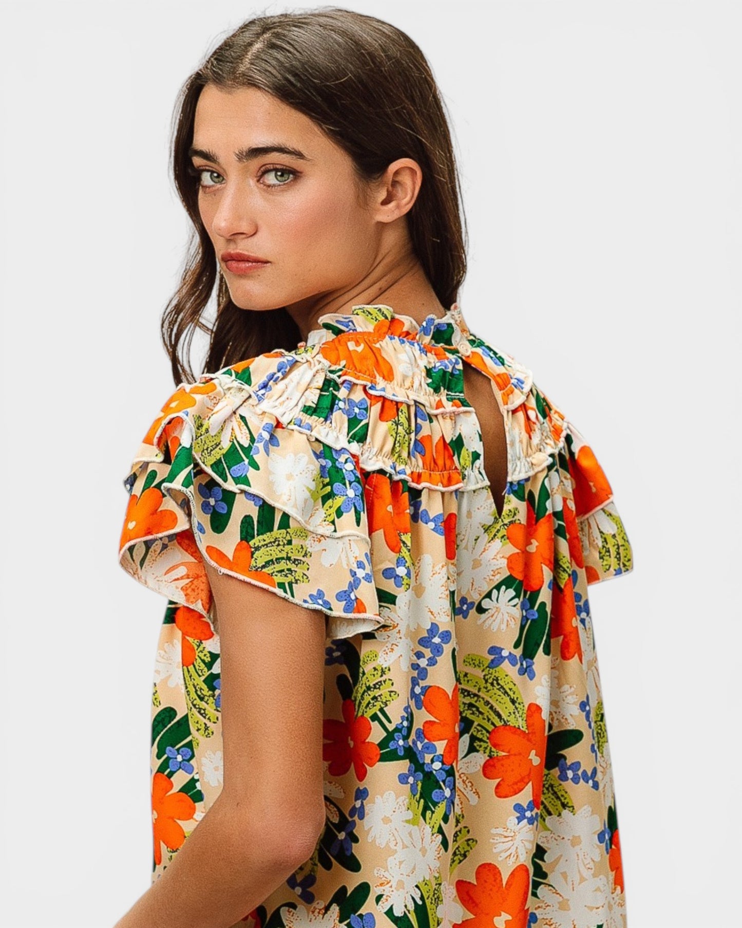 Woman wearing a colorful floral dress on a white background