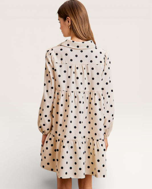 Woman wearing a polka dot dress on a plain background