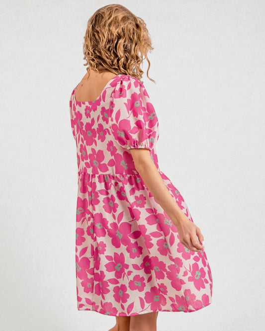 Woman wearing a pink floral dress on a white background