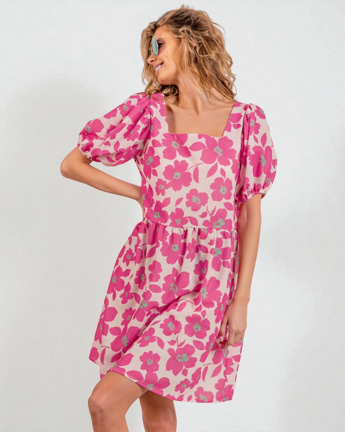Woman wearing a pink floral dress on a white background