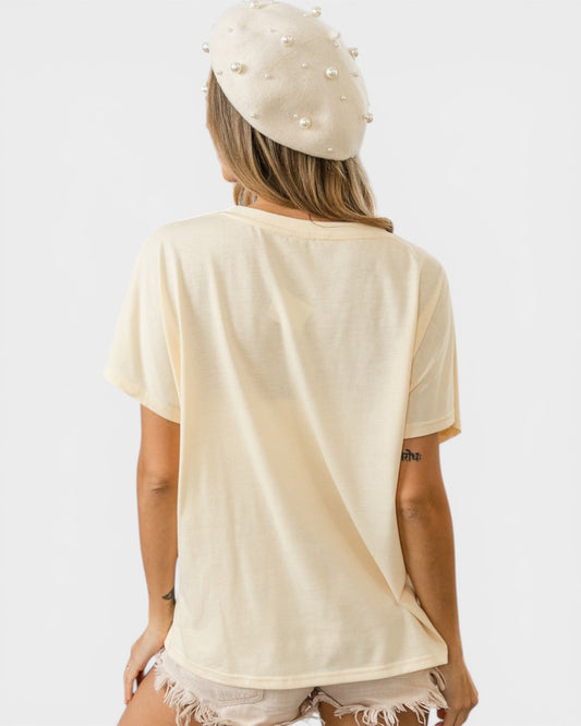Woman wearing a beige t-shirt and pearl headband on a white background