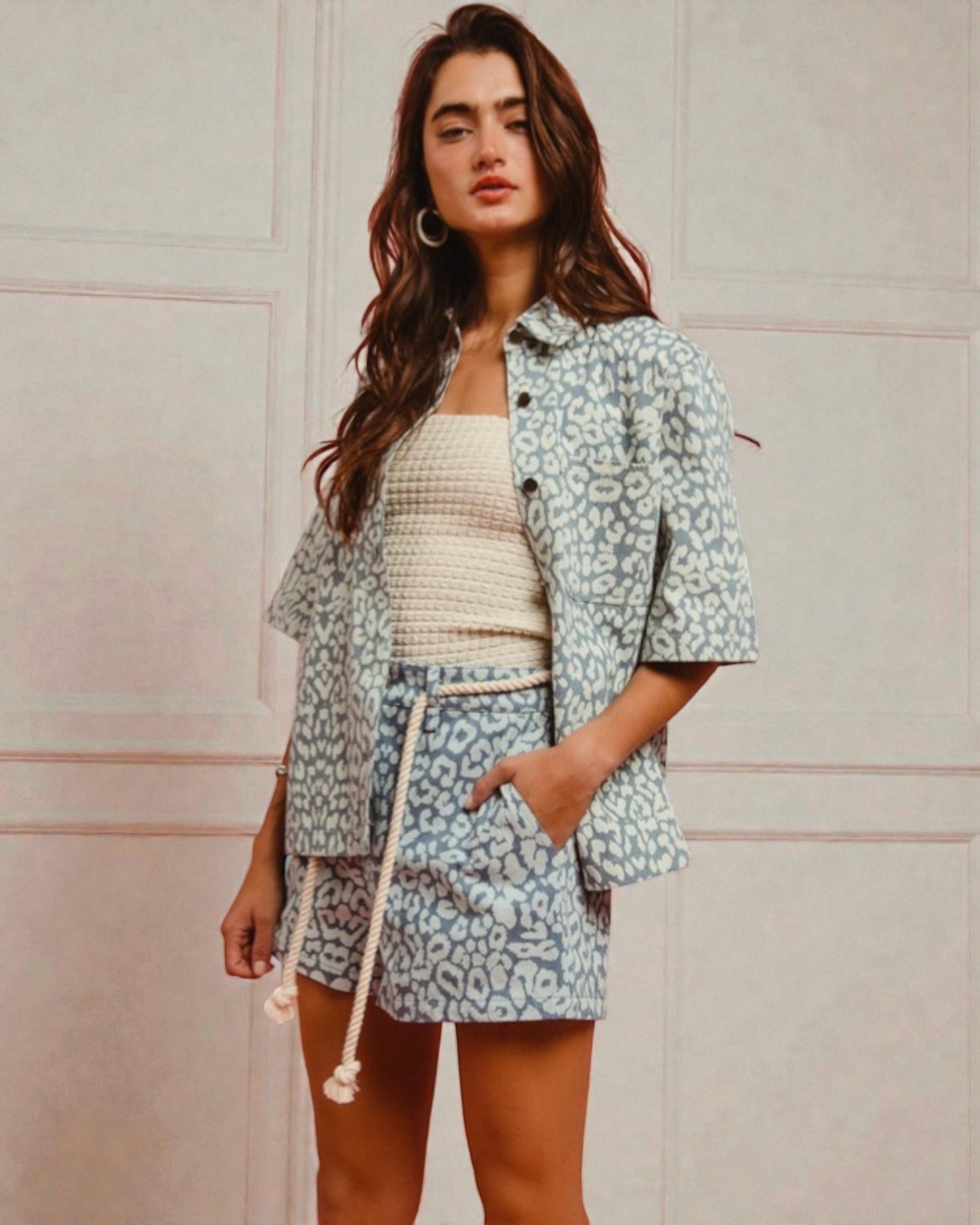 Woman wearing a patterned outfit against a plain background