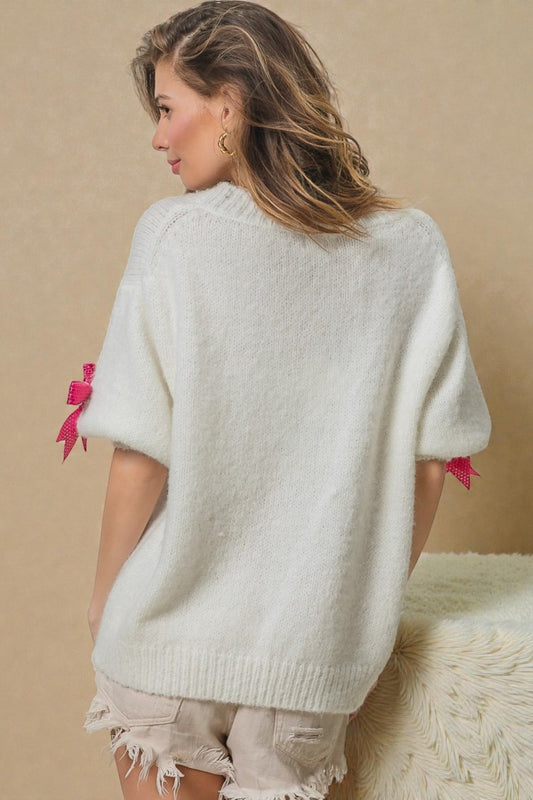 Woman wearing a white sweater with pink accents on a beige background