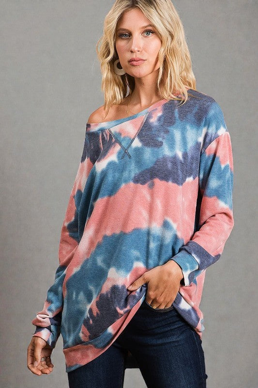 Woman wearing a tie-dye long-sleeve top against a gray background