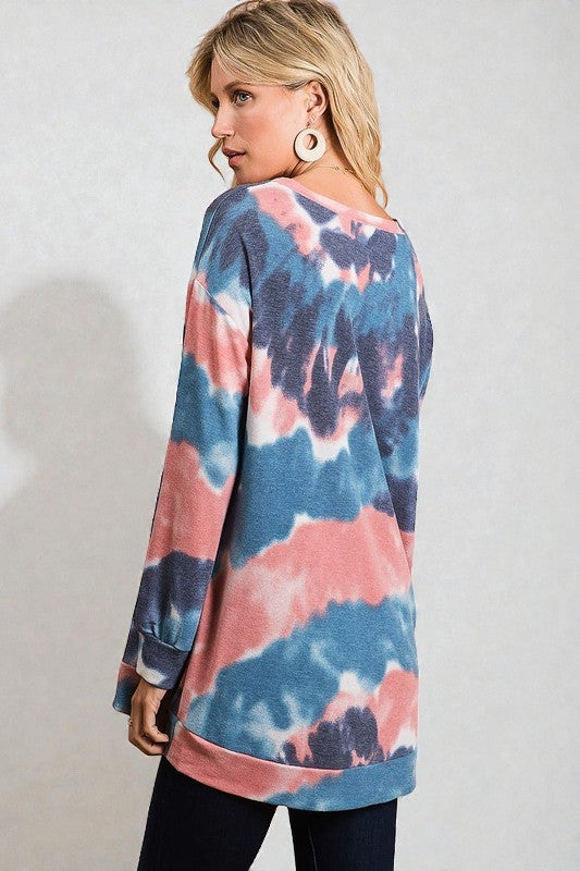 Woman wearing a tie-dye sweater with a plain background