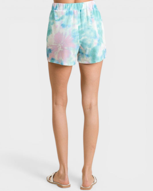 Tie-dye shorts worn by a person on a white background