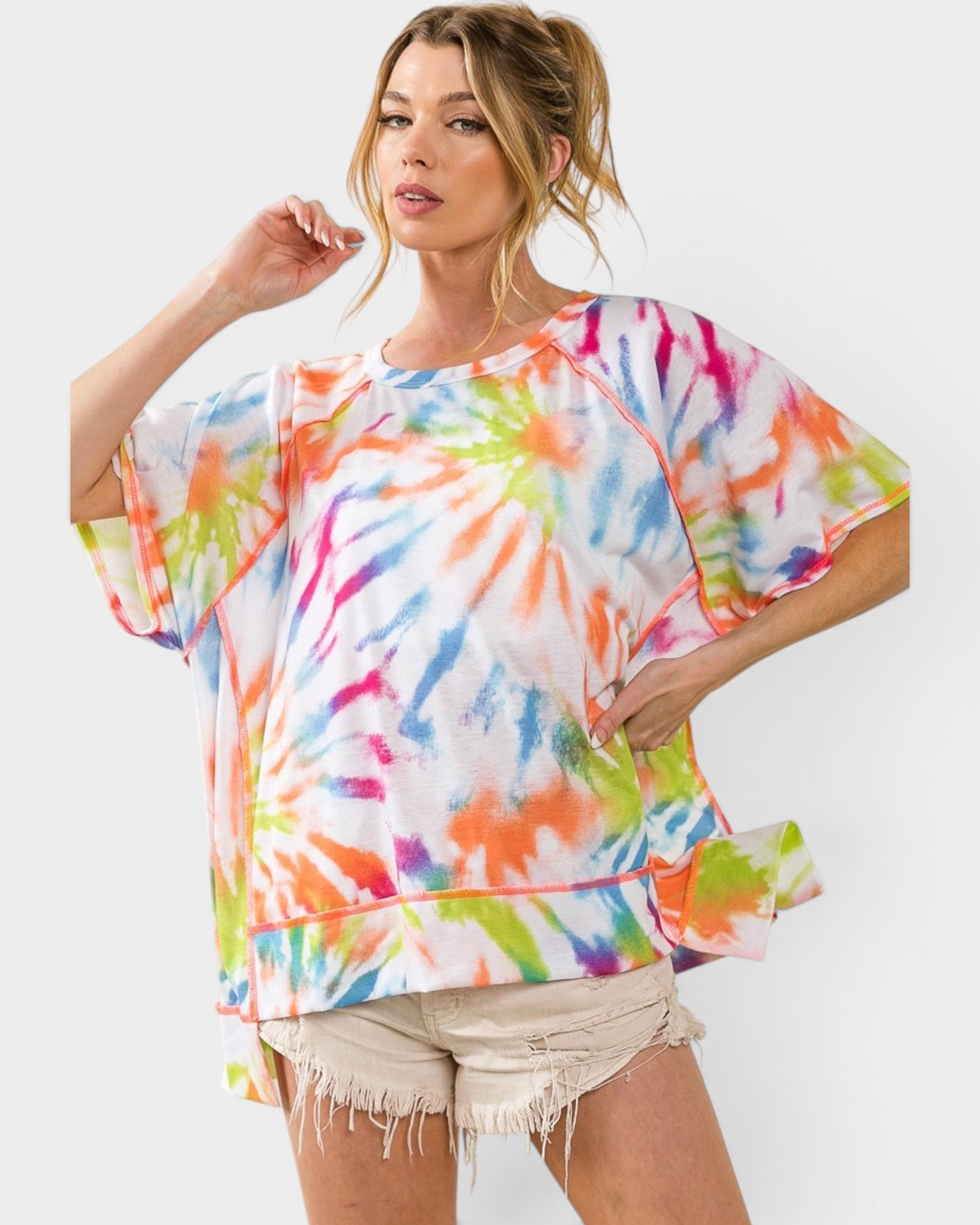 Woman wearing a colorful tie-dye shirt on a white background
