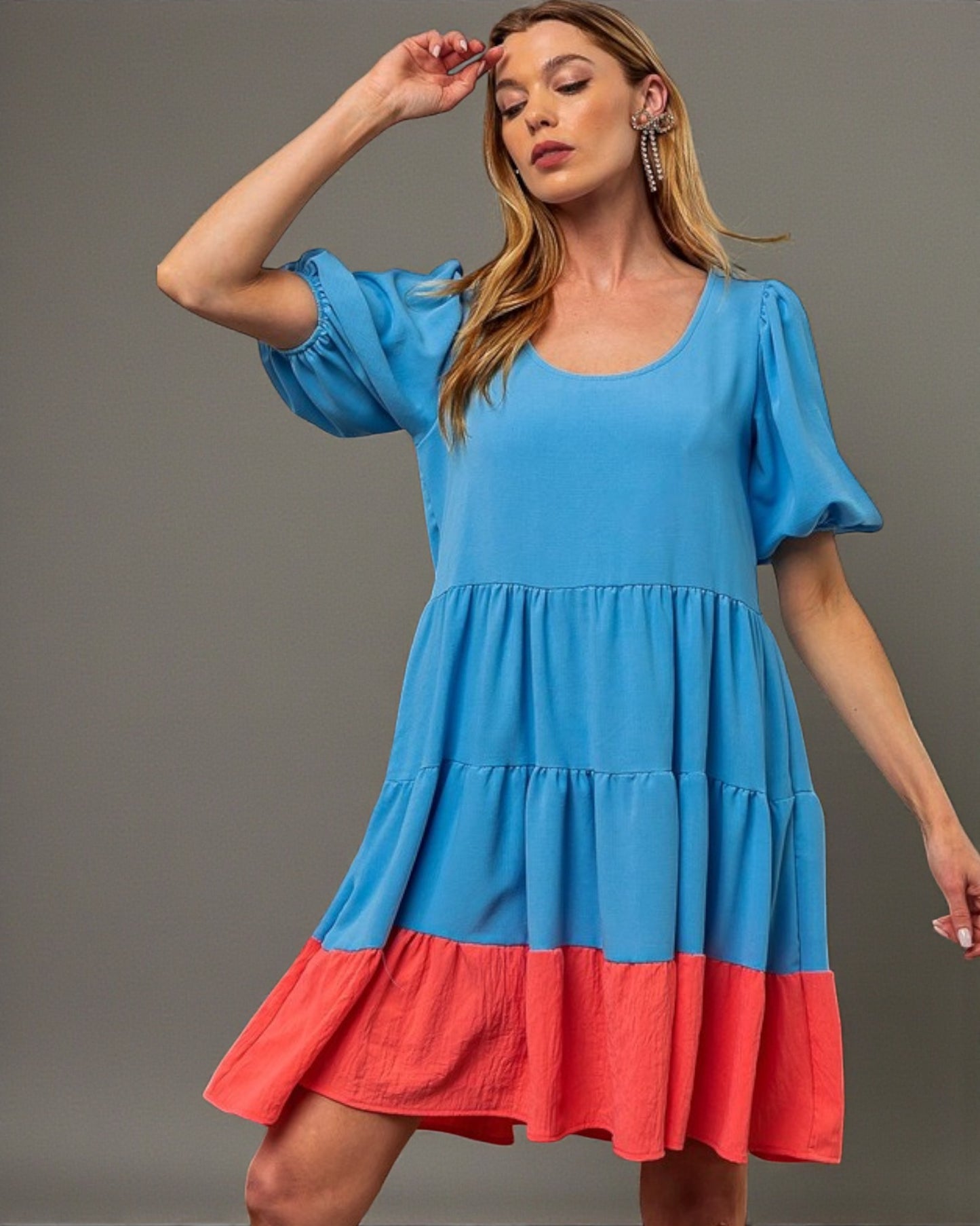 Woman wearing a blue and red dress against a gray background
