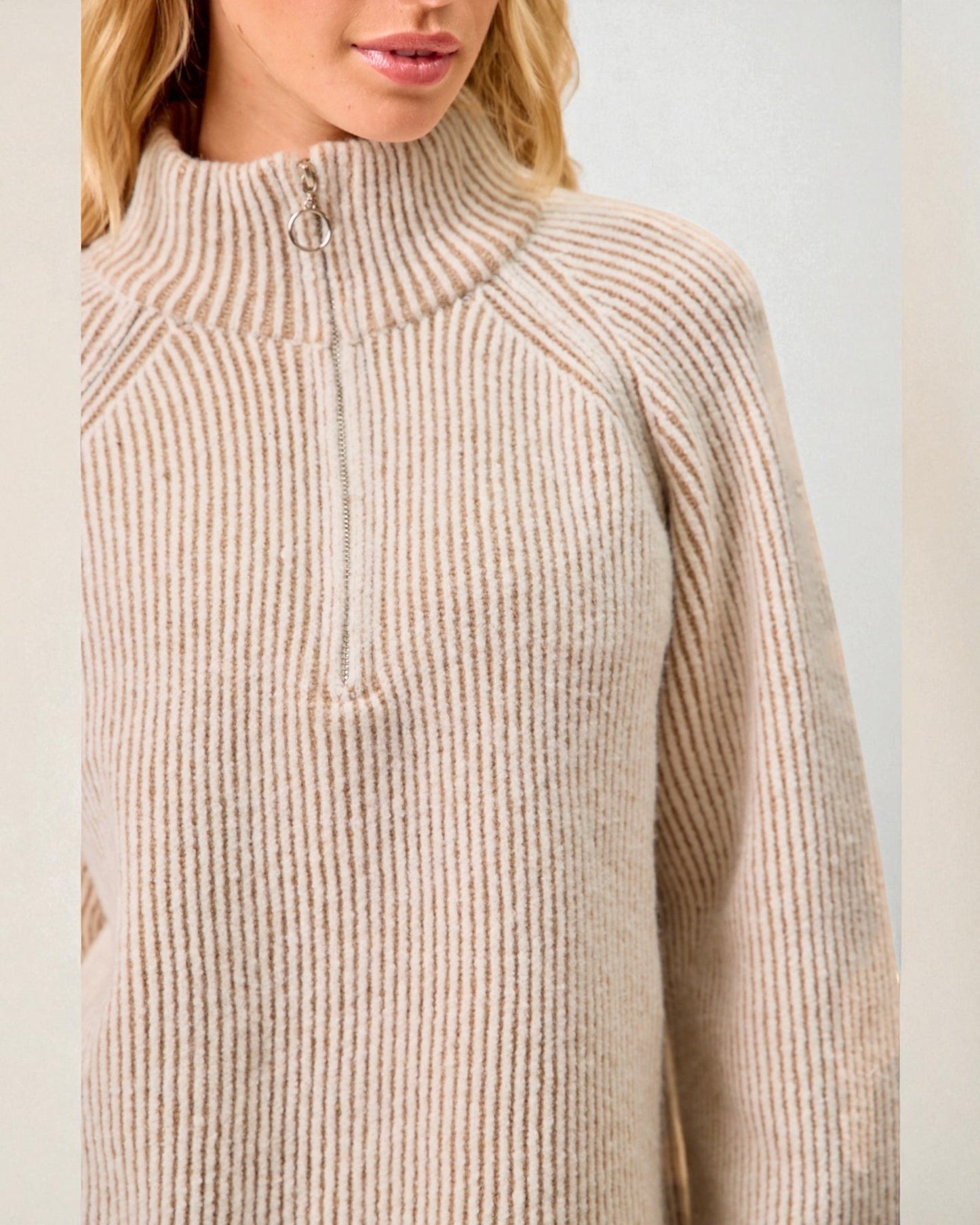 Beige ribbed sweater worn by a person on a plain background