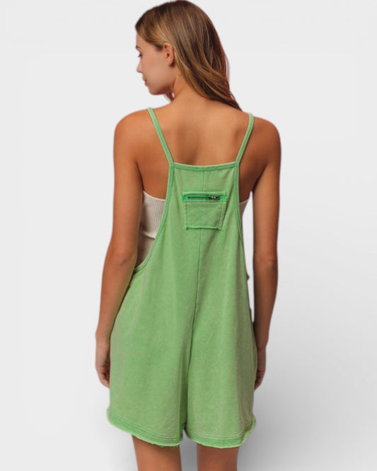 Person wearing a green romper on a white background