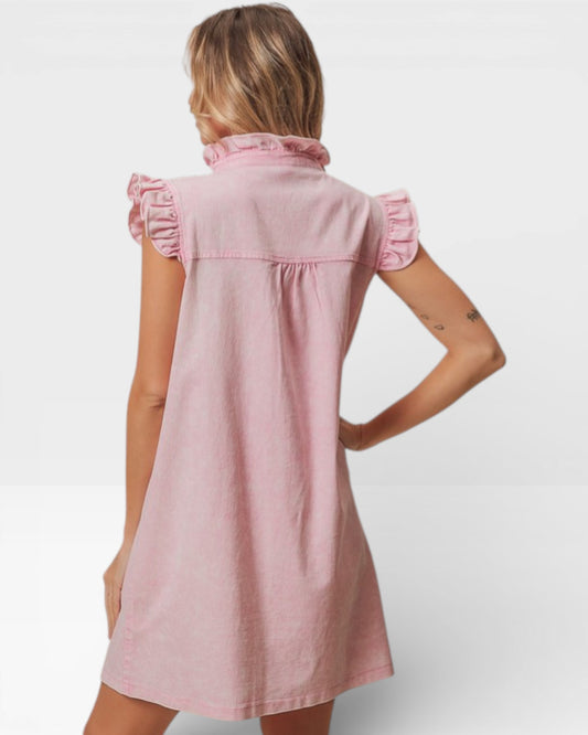 Woman wearing a pink dress with ruffled details on a white background