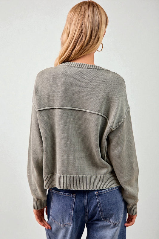 Person wearing a gray sweater with a white background