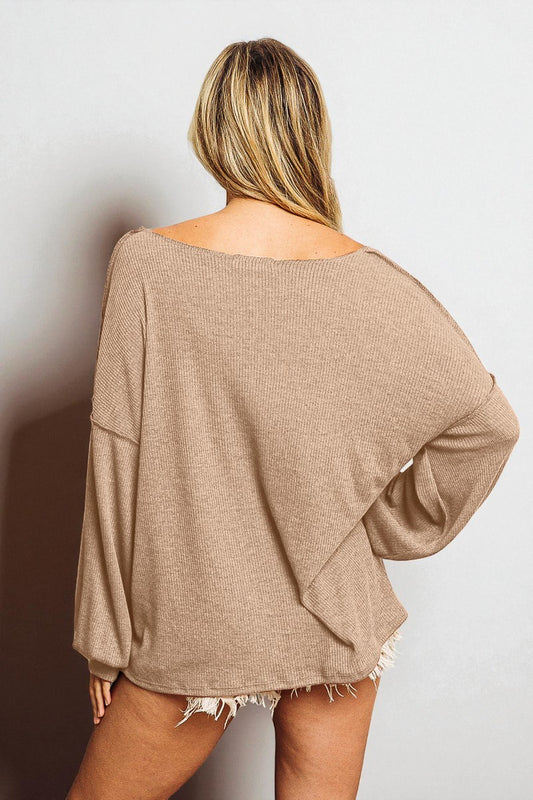 Person wearing a beige oversized sweater against a plain background