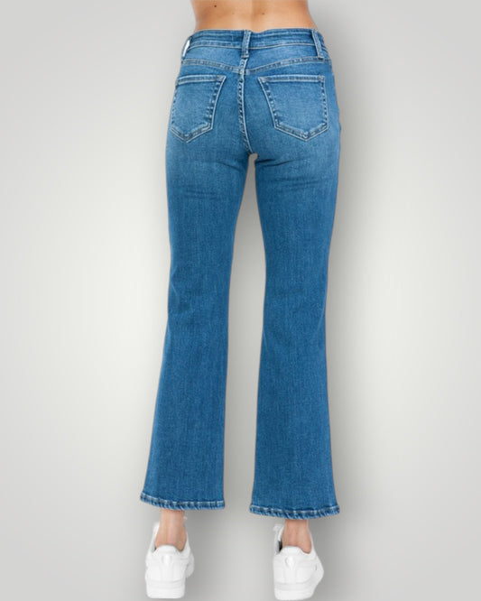 Blue jeans worn by a person on a plain background
