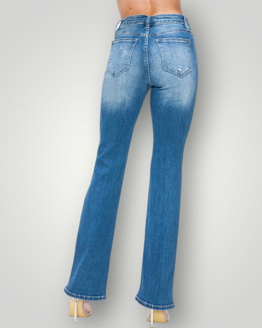 Blue jeans worn by a person on a plain background