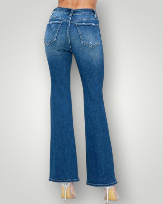 Blue jeans worn by a person on a plain background