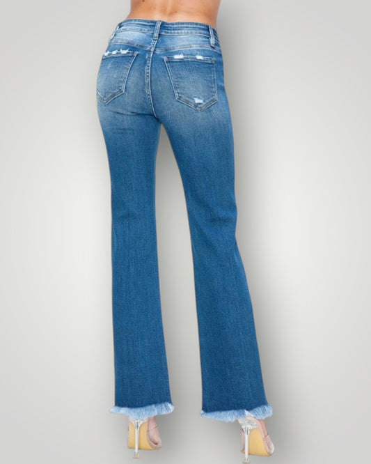 Blue jeans worn by a person on a plain background