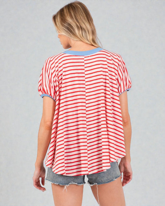 Woman wearing a red and white striped shirt with denim shorts on a gray background