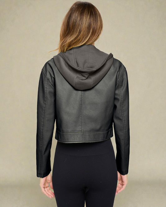 Person wearing a dark gray leather jacket with a hood on a beige background