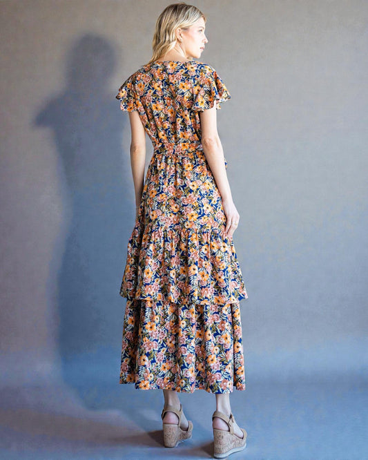 Woman wearing a floral dress against a plain background