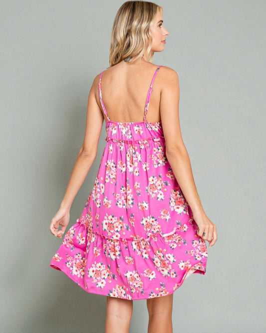 Woman wearing a pink floral dress against a gray background