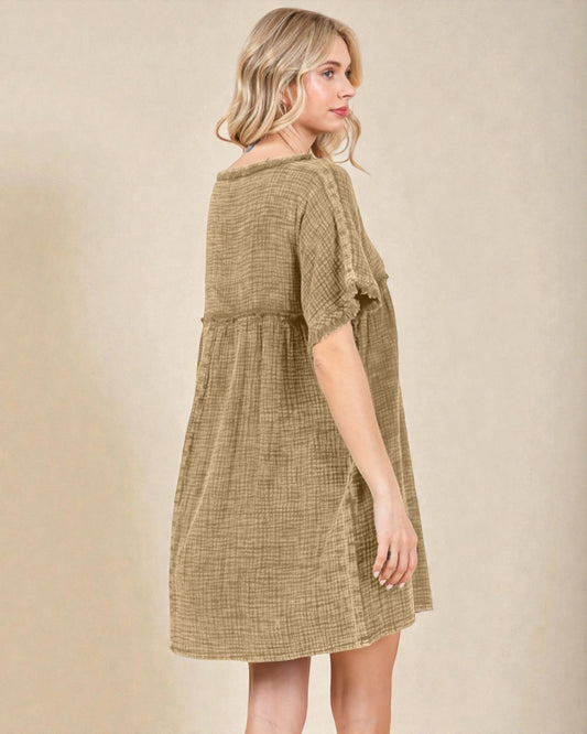 Woman wearing a green checkered dress against a beige background