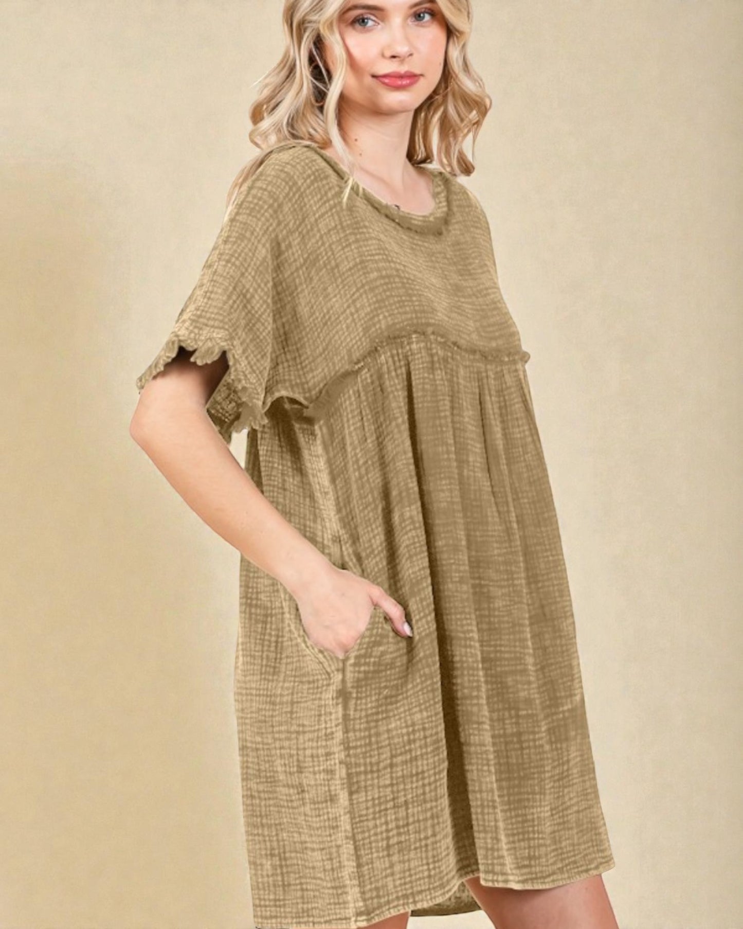 Woman wearing a green dress with a beige background