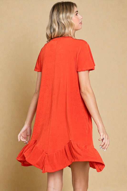 Woman wearing a red dress with ruffled hem on a beige background