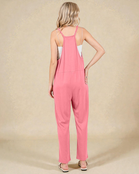 Woman wearing a pink jumpsuit on a beige background