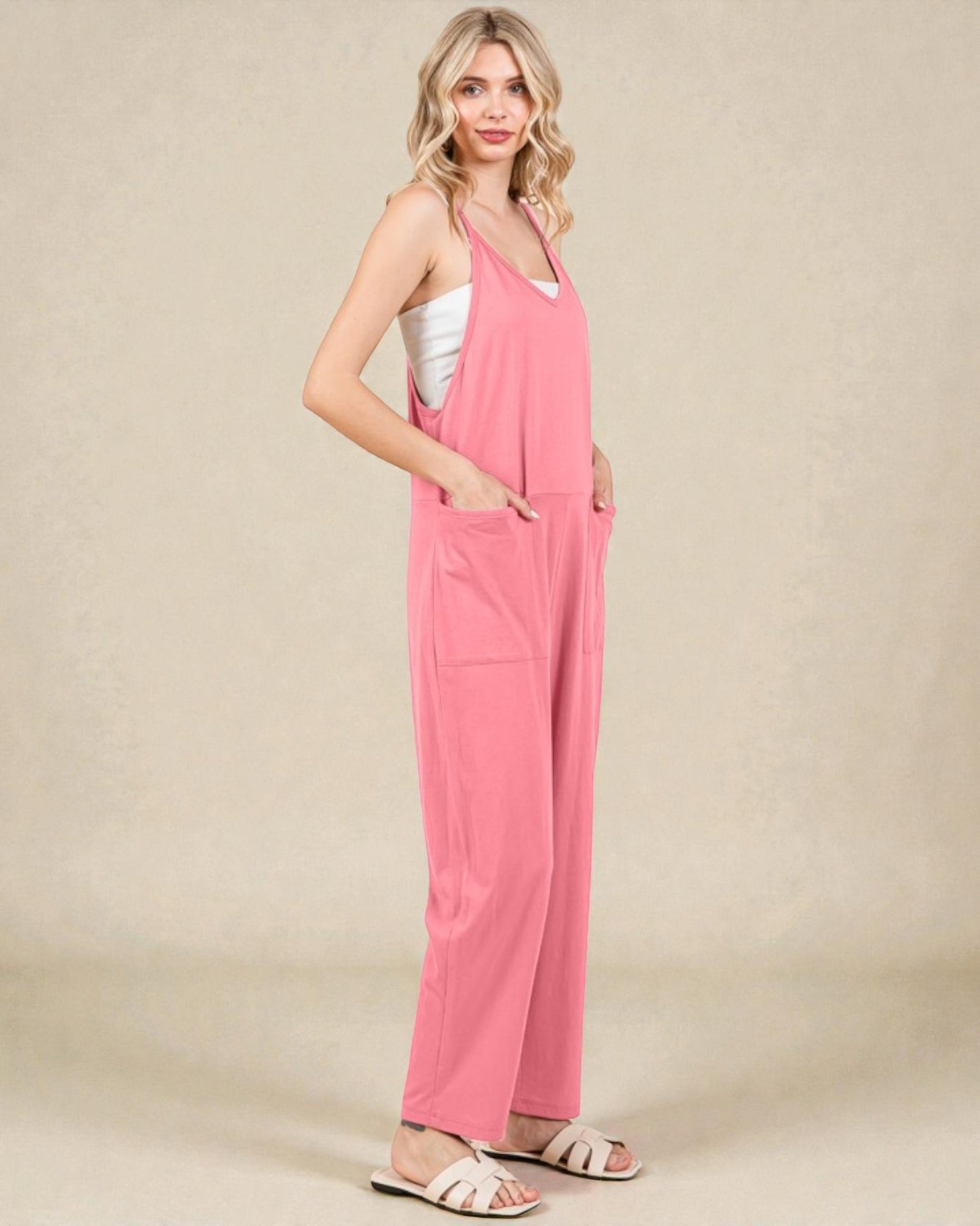 Woman wearing a pink jumpsuit on a beige background