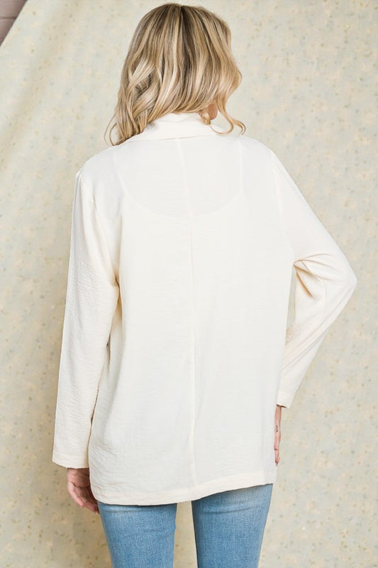 Person wearing a cream-colored cardigan against a neutral background