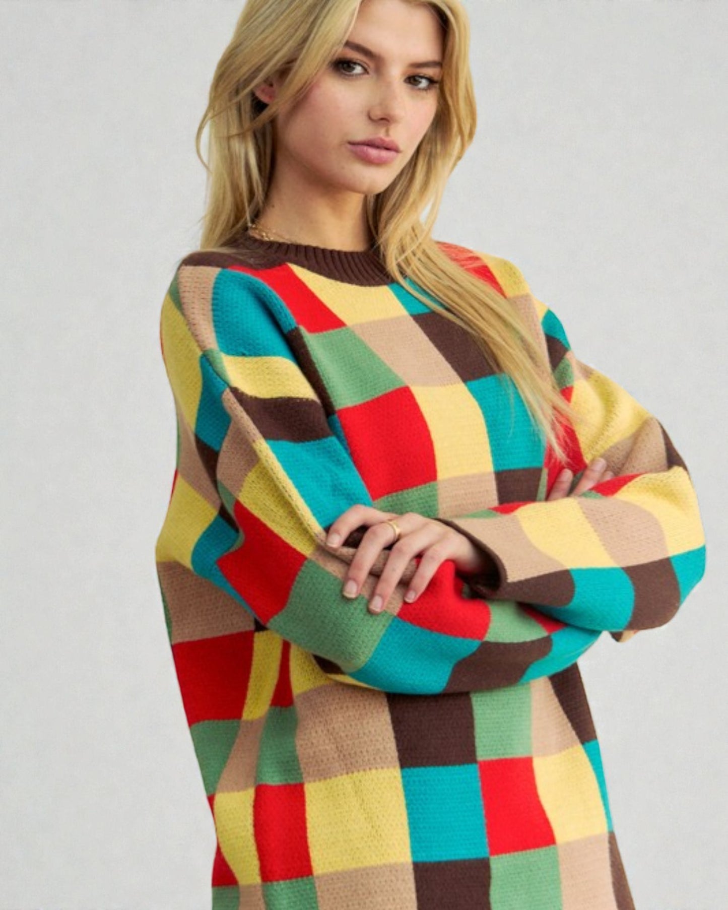 Woman wearing a colorful checkered sweater on a plain background