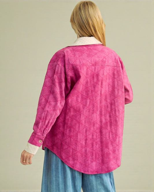 Person wearing a pink quilted jacket with a neutral background
