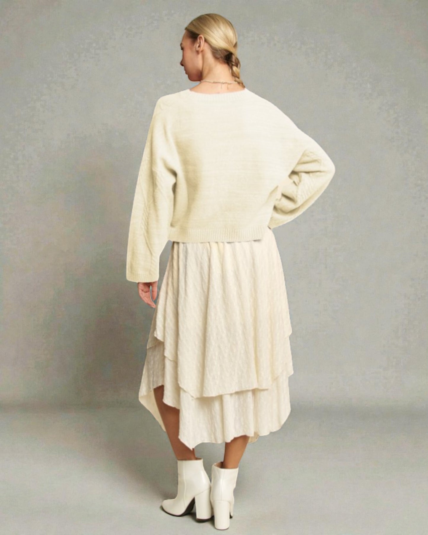 Woman wearing a cream-colored dress with a plain background