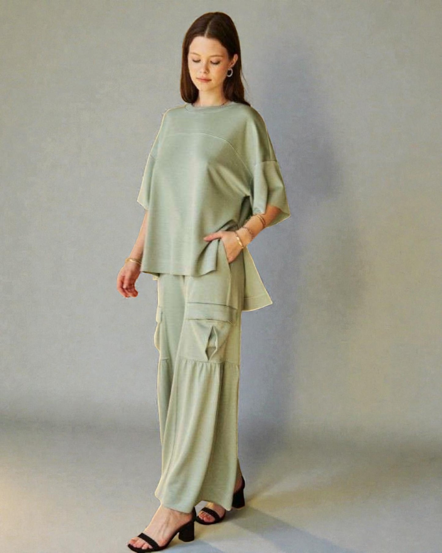 Woman wearing a light green outfit against a plain background