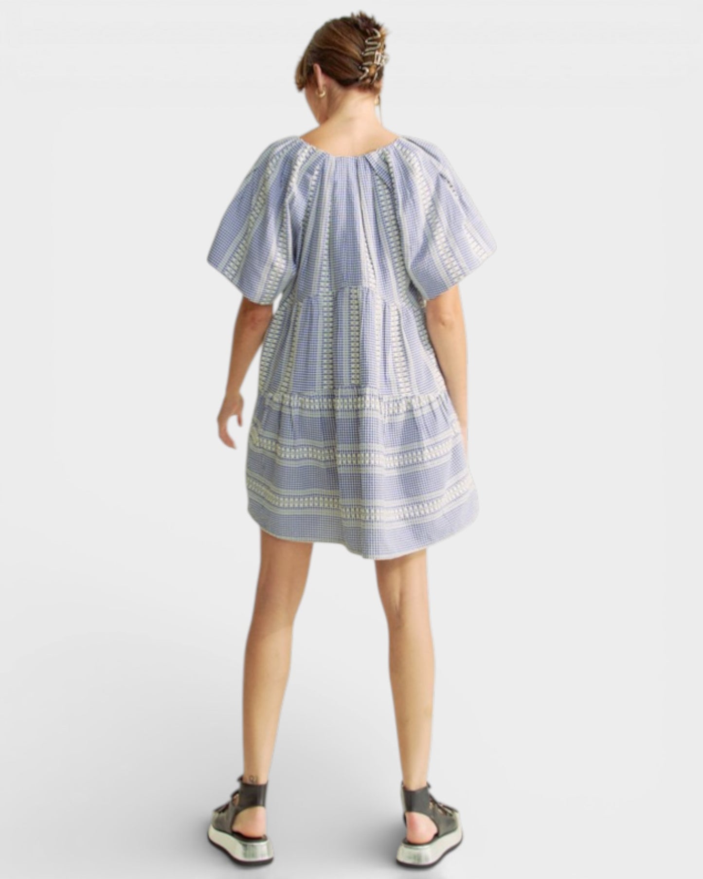 Person wearing a blue and white striped dress on a white background