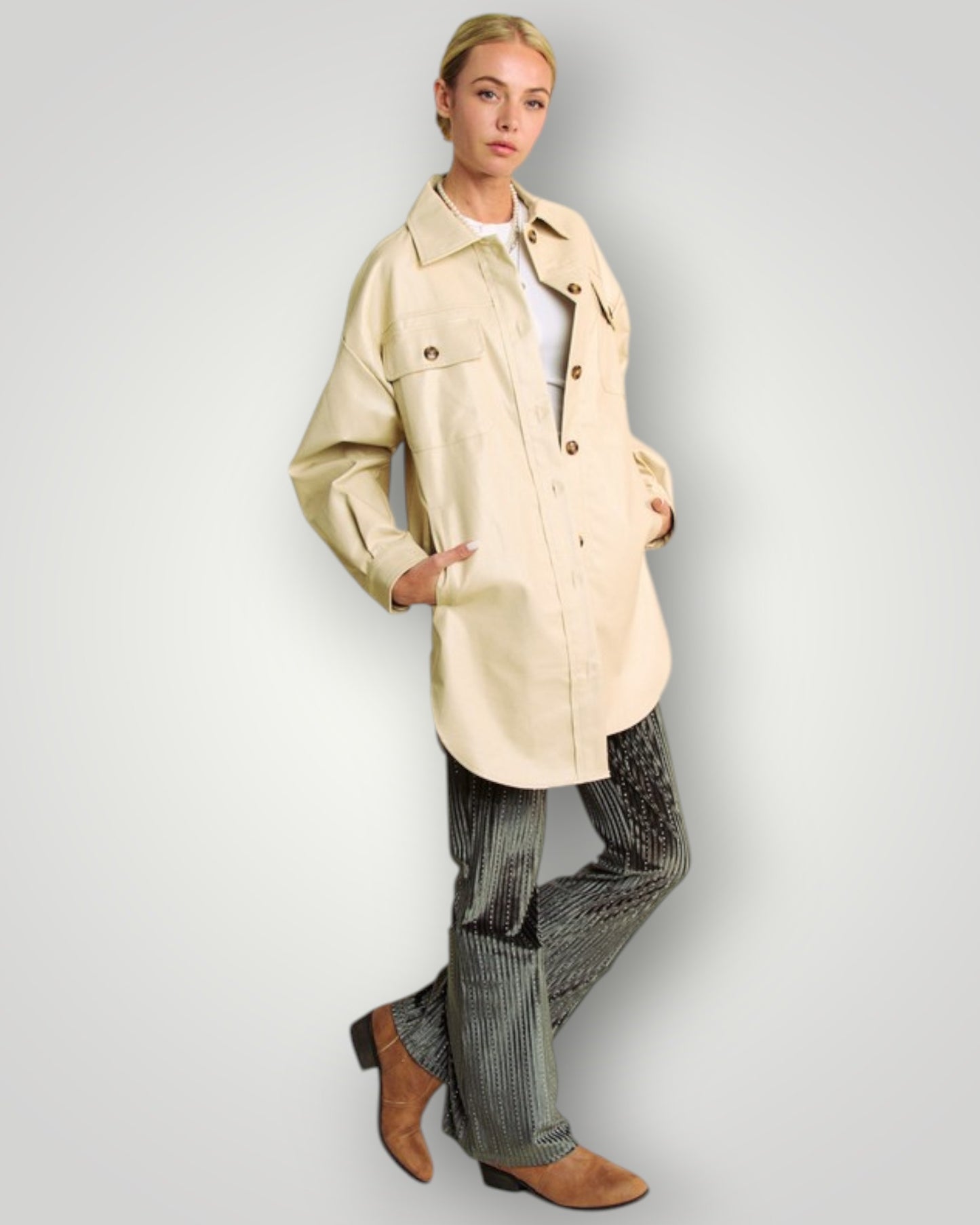Person wearing a beige trench coat on a plain background