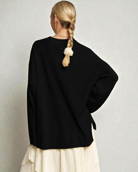 Person wearing a black sweater with a plain background