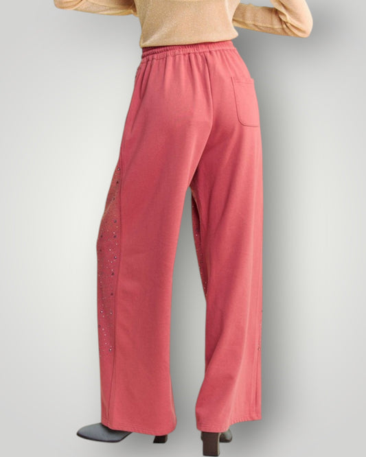 Pink pants with decorative side panels on a gray background