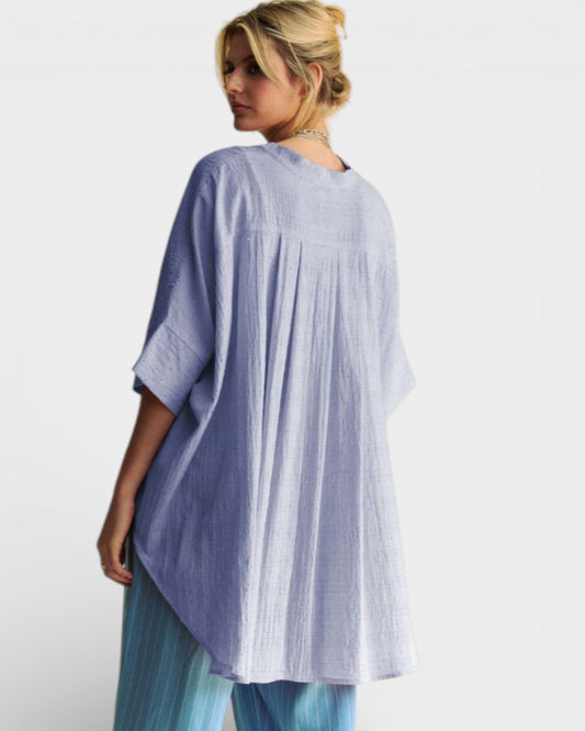 Woman wearing a light blue and white striped dress against a white background