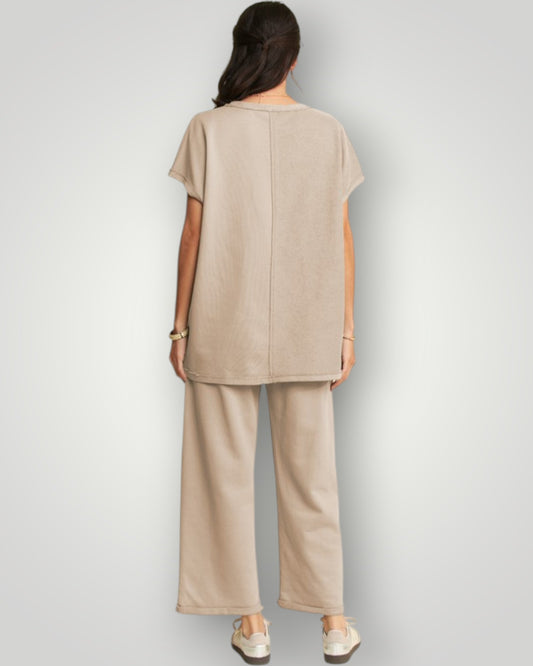 Person wearing a beige outfit on a plain background