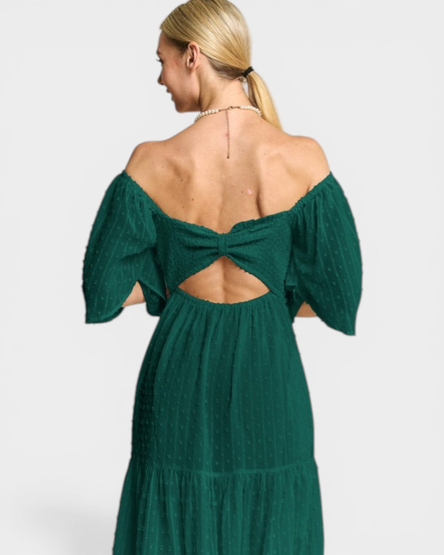 Green off-shoulder dress with cut-out back on a white background