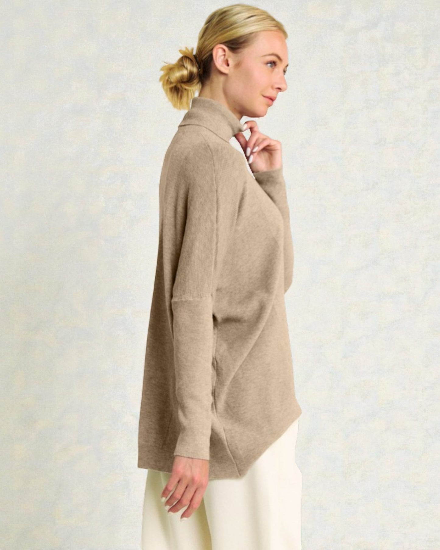 Woman wearing a beige cardigan against a light background