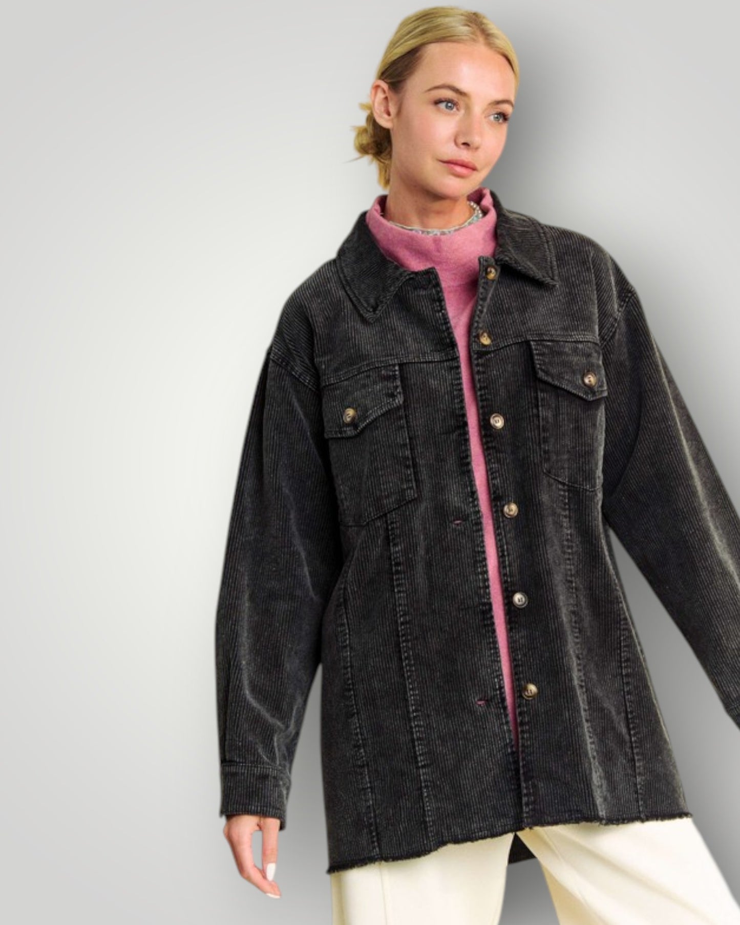 Woman wearing a black jacket over a pink shirt on a gray background