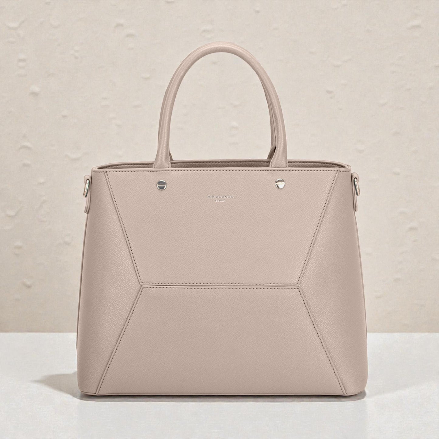 Beige handbag with geometric design on a light background